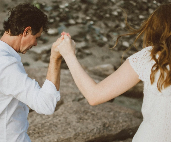 a man and a woman holding hands while standing next to each other